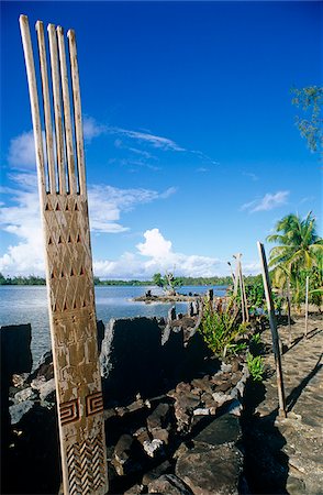 French Polynesia, Society Islands, Leeward Islands, Huahine Island, aka Matairea, Maeva. Numerous marae,  Polynesian sacred or ceremonial sites, dot the shore and hinterland of Lake Fauna Nui. The decorative wooden stele, or unu, were probably totems for the local family or tribe. Foto de stock - Direito Controlado, Número: 862-03887679