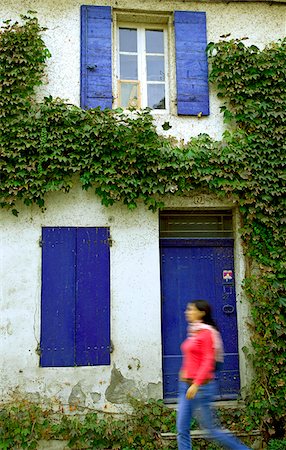 simsearch:862-07495901,k - Arles ; Bouches du Rhône (France) ; Une jeune femme marche devant une maison aux couleurs vives. Photographie de stock - Rights-Managed, Code: 862-03887773