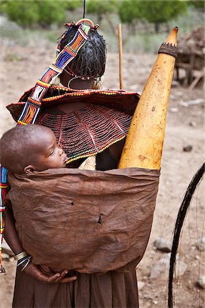 The Pokot have a small ceremony called Koyogho when a man pays his in-laws the balance of the agreed dowry for his wife. At the conclusion of the ritual, his wife is given a large gourd of milk which she carries home on her back with her youngest child. Stock Photo - Rights-Managed, Code: 862-03888711