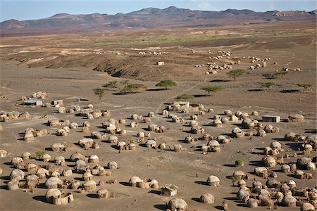 eastern province - Traditional palm-frond domed houses built by the Turkana people in barren, lava-strewn country near Loiengalani., east of Lake Turkana. Foto de stock - Direito Controlado, Número: 862-03888744