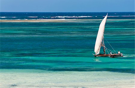 A traditional outrigger canoe sails close to the shore at Diani Beach. Stock Photo - Rights-Managed, Code: 862-03888743