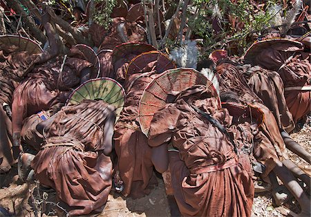 At the conclusion of a Ngetunogh ceremony, Pokot initiates rush to a sacred tree and crouch briefly while women and girls hurl abuse at them. After disbursing, they meet that evening to feast on a bull. The following day they return home and remove their ceremonial attire. Stock Photo - Rights-Managed, Code: 862-03888764