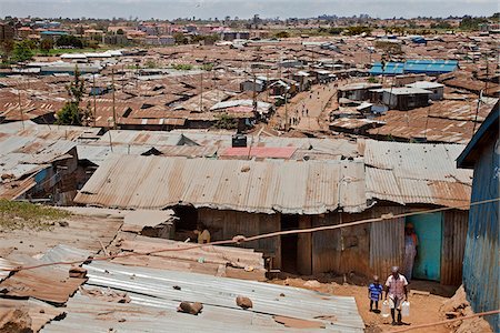 Kibera est le plus grand bidonville d'Afrique et parmi les plus importantes au monde. Il abrite environ 1 million de personnes dans des conditions exiguës, manque d'hygiène dans la banlieue de Nairobi. Appartements de grande hautes modernes sont visibles au loin. Photographie de stock - Rights-Managed, Code: 862-03888770
