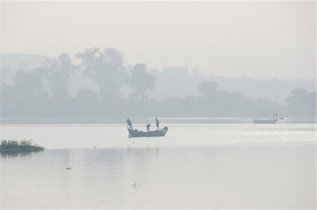 dugout boat - On a foggy dawn, fishermen try their chance at the Niger river. Bamako, Mali, West Africa Stock Photo - Rights-Managed, Code: 862-03888773