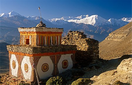 Nepal, Himalaya, Mustang. A decorative chorten, or Buddhist shrine, known as Chhyungkar guards the trail near Syangboche hamlet and the Syangboche Pass while the massive Annapurna massif frames the horizon. Stock Photo - Rights-Managed, Code: 862-03888950