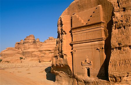 Saudi Arabia, Madinah, nr. Al-Ula, Madain Saleh (aka Hegra). Now a UNESCO World Heritage Site, the ancient remains of Qasr al-Bint - a cluster of rock-cut tombs and part of an ancient Nabatean settlement - stand amidst imposing cliffs and striking rocky outcrops. Foto de stock - Direito Controlado, Número: 862-03889523