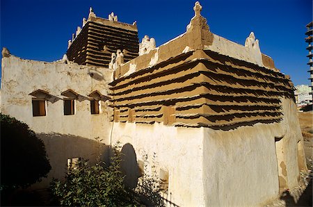 Saudi Arabia, Asir, Abha. Built in around 1927 for a local governor, the Shada Palace is a fine example of one of the region's traditional forms of architecture (sometimes called raqaf) where adobe walls (khulb) are protected from erosion by projecting courses of schist (raqaf). Stock Photo - Rights-Managed, Code: 862-03889534