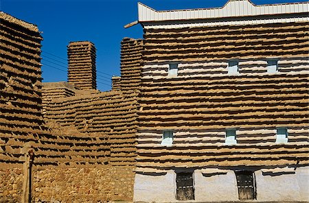 L'Asir, Arabie saoudite, Al-Alkhalaf. Le village de Al-Alkhalaf est parmi les plus beaux exemples d'architecture (parfois appelé raqaf) des formes traditionnelles de la région avec ressemblant à la tour de maisons avec des murs en adobe (khulb) protégés contre l'érosion en cours de projections de schiste (raqaf). Photographie de stock - Rights-Managed, Code: 862-03889535