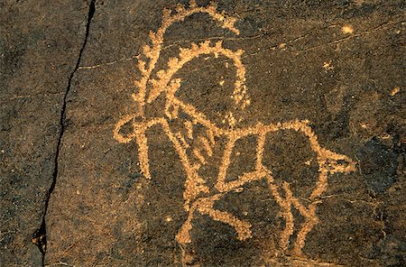 rock art on cliffs - Saudi Arabia, Najran, Bir Hima. One of the country's most important rock art sites is remote Bir Hima where hundreds of petroglyphs have been incised in cliffs and overhangs. Stock Photo - Rights-Managed, Code: 862-03889538