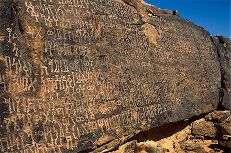 petroglyphs - Saudi Arabia, Najran, Bir Hima. One of the country's most important rock art sites is remote Bir Hima where hundreds of petroglyphs and ancient insrcriptions in Thamudic and Sabean (or Sabaic) scripts have been incised in cliffs and overhangs. Stock Photo - Rights-Managed, Code: 862-03889539