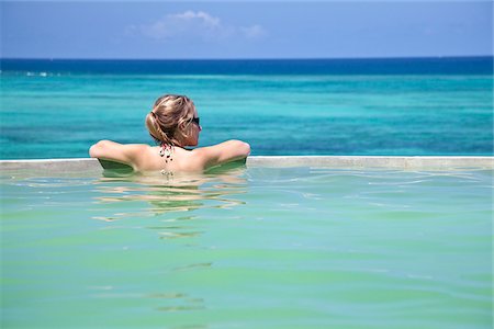Zanzibar, Shooting Star Lodge. A guest relaxes in the infinity pool overlooking Zanzibar's east coast. Stock Photo - Rights-Managed, Code: 862-03890034