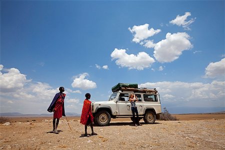 Tanzania, Olduvai. Maasai children watch as a tourist looks out over the landscape around Olduvai gorge. Foto de stock - Con derechos protegidos, Código: 862-03890044