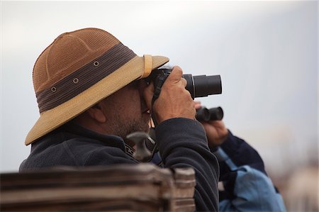 simsearch:862-03808677,k - Un homme dans un casque colonial, regarder le match sur le Serengetti en Tanzanie Photographie de stock - Rights-Managed, Code: 862-03890076
