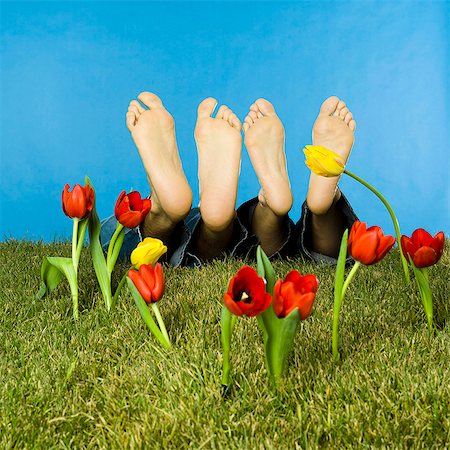 sleeping man foot - Barefoot couple lying in lawn, fake tulips Photographie de stock - Rights-Managed, Code: 877-06834180
