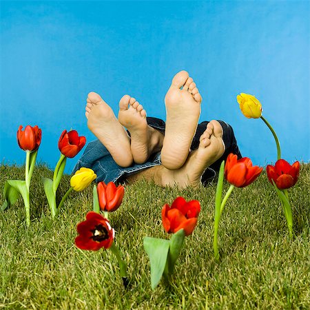 sleeping man foot - Barefoot couple lying in lawn, fake tulips Photographie de stock - Rights-Managed, Code: 877-06834181