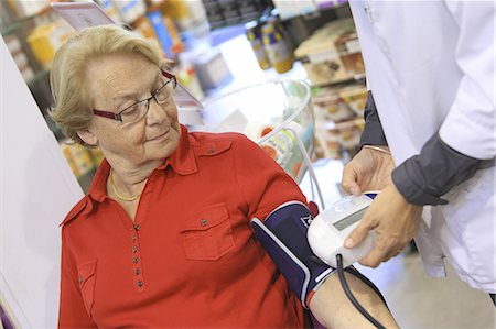 France, drugstore, pharmacist checking client's bloodpressure Photographie de stock - Rights-Managed, Code: 877-06835441