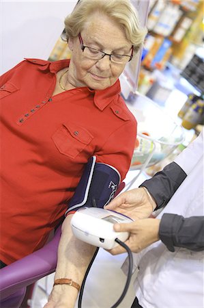 France, drugstore, pharmacist checking client's bloodpressure Photographie de stock - Rights-Managed, Code: 877-06835442