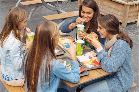 fast food restaurant - Teenager drinking some soft drink and eating an hamburger Stock Photo - Rights-Managed, Code: 877-06835685