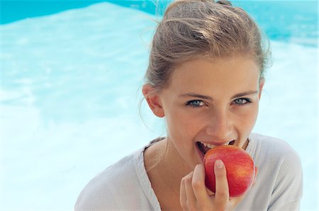 Teenage girl eating a red apple Stock Photo - Rights-Managed, Code: 877-06835714