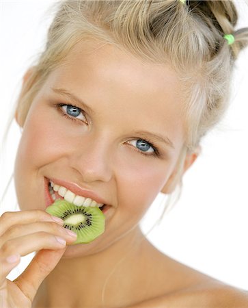 Portrait woman smiling, eating slice of kiwi (fruit) Stock Photo - Rights-Managed, Code: 877-06835919