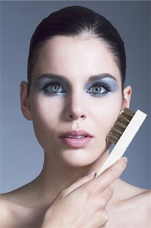 simsearch:877-06833698,k - Portrait of a young woman using steel brush on her cheek Foto de stock - Con derechos protegidos, Código: 877-06836180