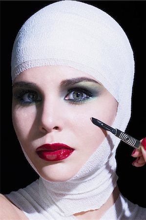 scalpel - Young woman holding scalpel, bandages on head Photographie de stock - Rights-Managed, Code: 877-06836225