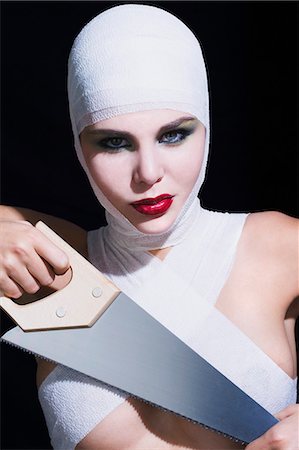 simsearch:877-06835996,k - Portrait of a young woman holding handsaw, bandages on head and breast Photographie de stock - Rights-Managed, Code: 877-06836229