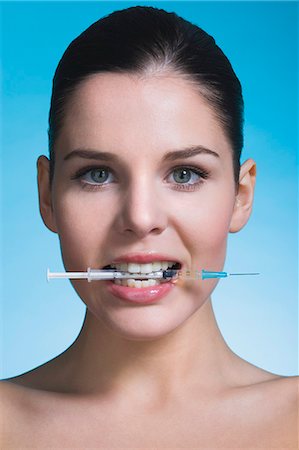 simsearch:877-06836341,k - Young woman biting syringe Stock Photo - Rights-Managed, Code: 877-06836282