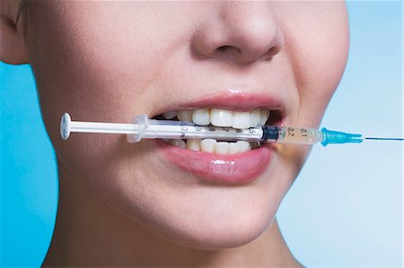 simsearch:877-06836341,k - Young woman biting syringe Stock Photo - Rights-Managed, Code: 877-06836283