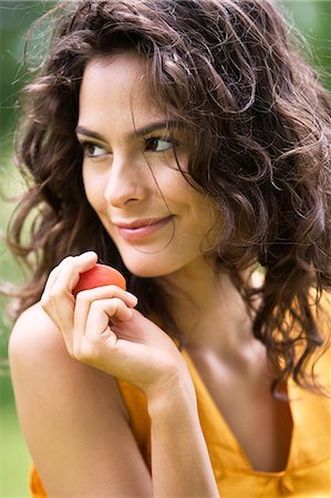 simsearch:6108-05862422,k - Portrait of a young woman holding an apricot Foto de stock - Con derechos protegidos, Código: 877-06832191