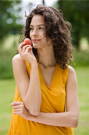 summer eating and clothes - Young woman holding an apricot Stock Photo - Rights-Managed, Code: 877-06832193