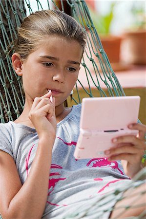 simsearch:877-06833417,k - Portrait of a little girl playing with Nintendo DS, in hammock Stock Photo - Rights-Managed, Code: 877-06832361