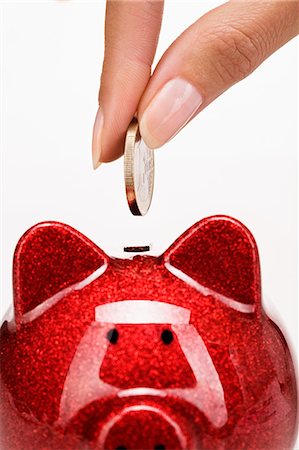 euro - Woman's hand putting a coin in a piggy bank Foto de stock - Con derechos protegidos, Código: 877-06832577