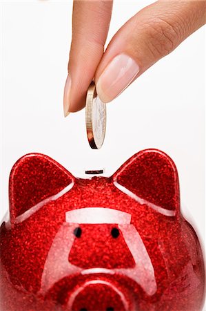 piggy bank hand - Woman's hand putting a coin in a piggy bank Stock Photo - Rights-Managed, Code: 877-06832577