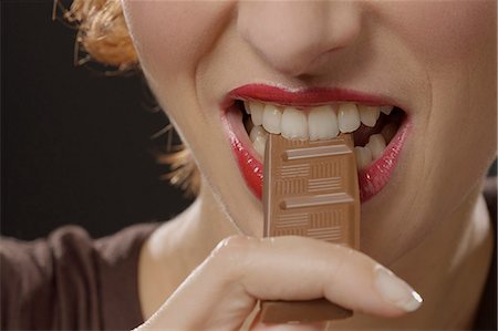 Woman eating chocolate, close-up of mouth Foto de stock - Con derechos protegidos, Código: 877-06832797