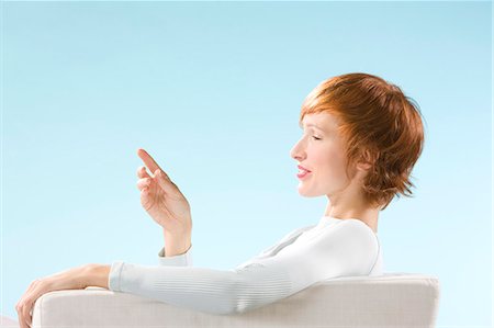 simsearch:400-07712720,k - Woman looking at her hand in a clear blue background Stock Photo - Rights-Managed, Code: 877-06832875