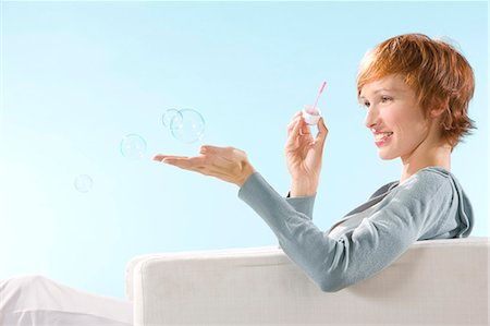 simsearch:877-06833353,k - Portrait of woman on light blue background, playing with bubbles Photographie de stock - Rights-Managed, Code: 877-06832877