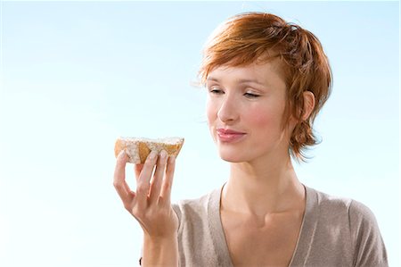 simsearch:877-06832874,k - Portrait of woman holding a sandwich on light blue background Fotografie stock - Rights-Managed, Codice: 877-06832899