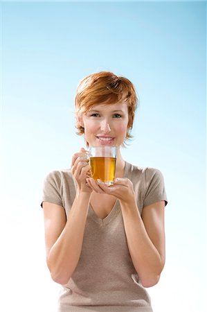 simsearch:877-06832874,k - Portrait of woman holding a cup of tea on light blue background Fotografie stock - Rights-Managed, Codice: 877-06832900