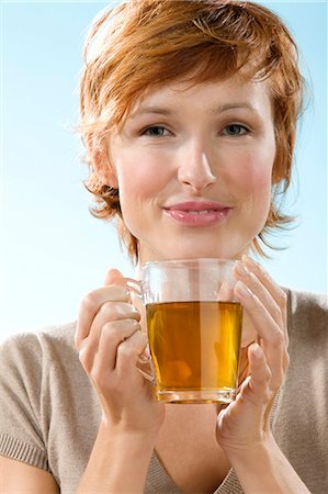 Portrait of woman holding a cup of tea on light blue background Stock Photo - Rights-Managed, Code: 877-06832901