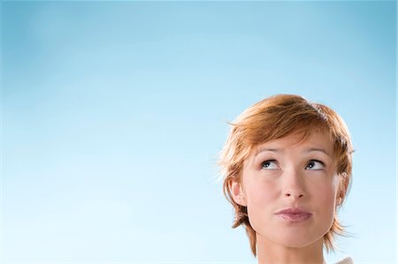 face looking up - Portrait of woman on light blue background Stock Photo - Rights-Managed, Code: 877-06832927