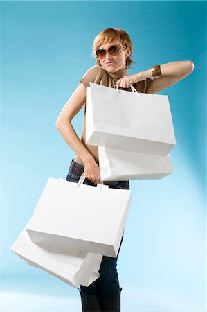 simsearch:877-06832874,k - Portrait of woman with shopping bag on light blue background Fotografie stock - Rights-Managed, Codice: 877-06832934