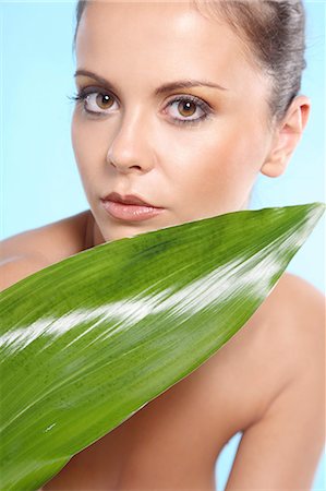 Young woman holding an aspidistra leaf Stock Photo - Rights-Managed, Code: 877-06832944