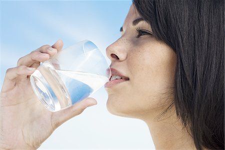 drinking water - Brown-haired young woman drinking a glass of water Stock Photo - Rights-Managed, Code: 877-06833065