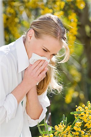 sick outside - Young woman blowing her nose in a garden Stock Photo - Rights-Managed, Code: 877-06833076