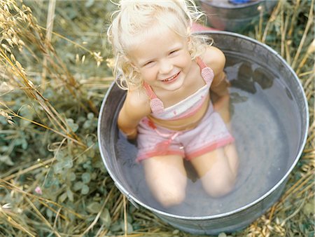 Little girl in metal basin Stockbilder - Lizenzpflichtiges, Bildnummer: 877-06833271