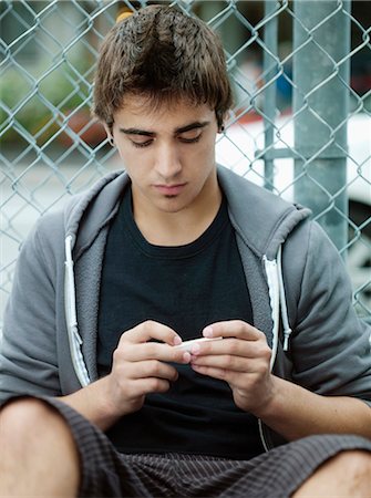 simsearch:877-06833900,k - Teenage boy rolling a joint Stock Photo - Rights-Managed, Code: 877-06833909