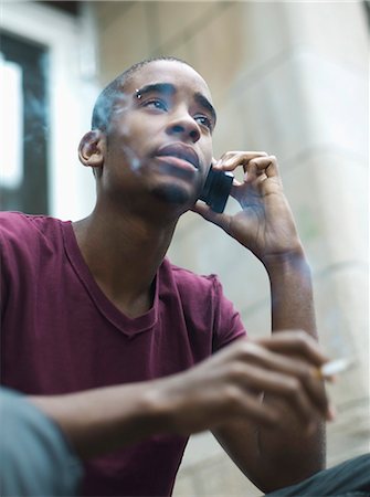 Teenage boy smoking while phoning Stock Photo - Rights-Managed, Code: 877-06833928