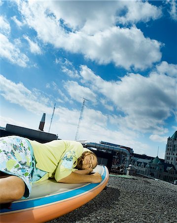 simsearch:877-06835760,k - Teenage girl lying on windsurf board on building roof Stock Photo - Rights-Managed, Code: 877-06833946