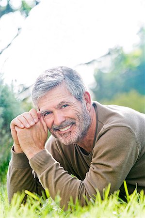 Mature man smiling laying on the grass Stock Photo - Rights-Managed, Code: 877-07460417